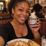 Woman at a restaurant holding Debloat